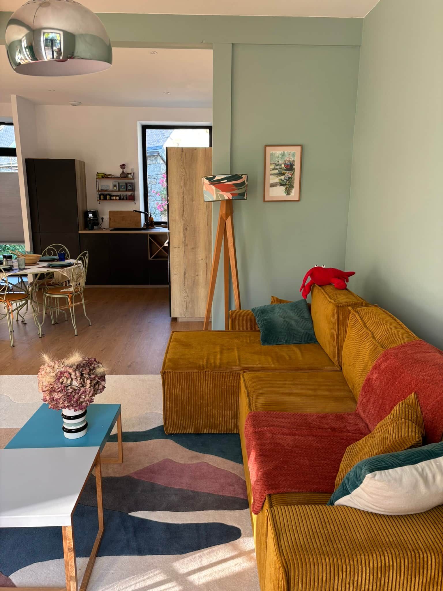A living room with a sofa, a coffee table, and a dining area with chairs and a table.
