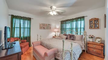 A bedroom with a bed, a chair, a desk, and a cabinet.