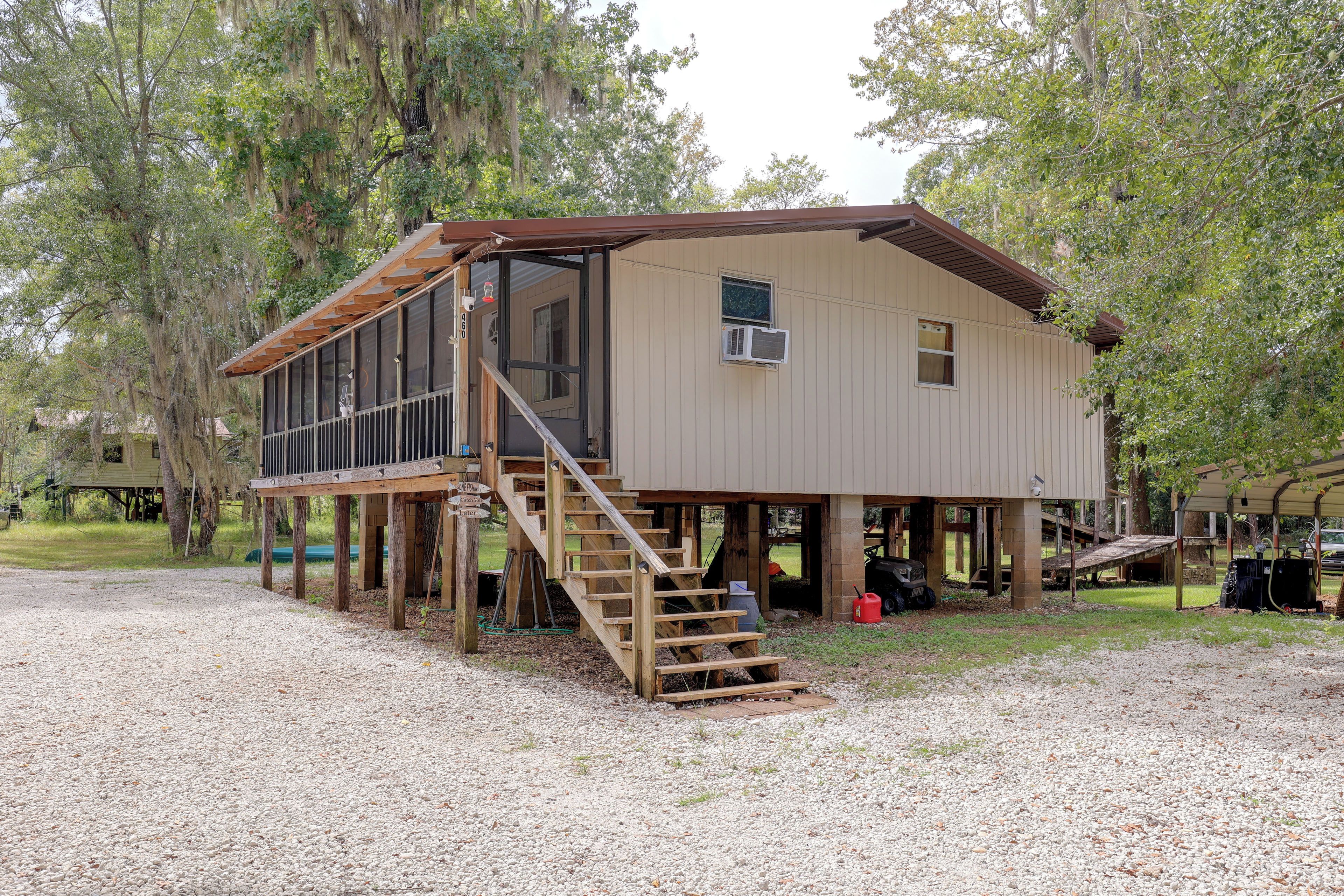 A two-story wooden cabin with a deck and a staircase leading to the upper level.