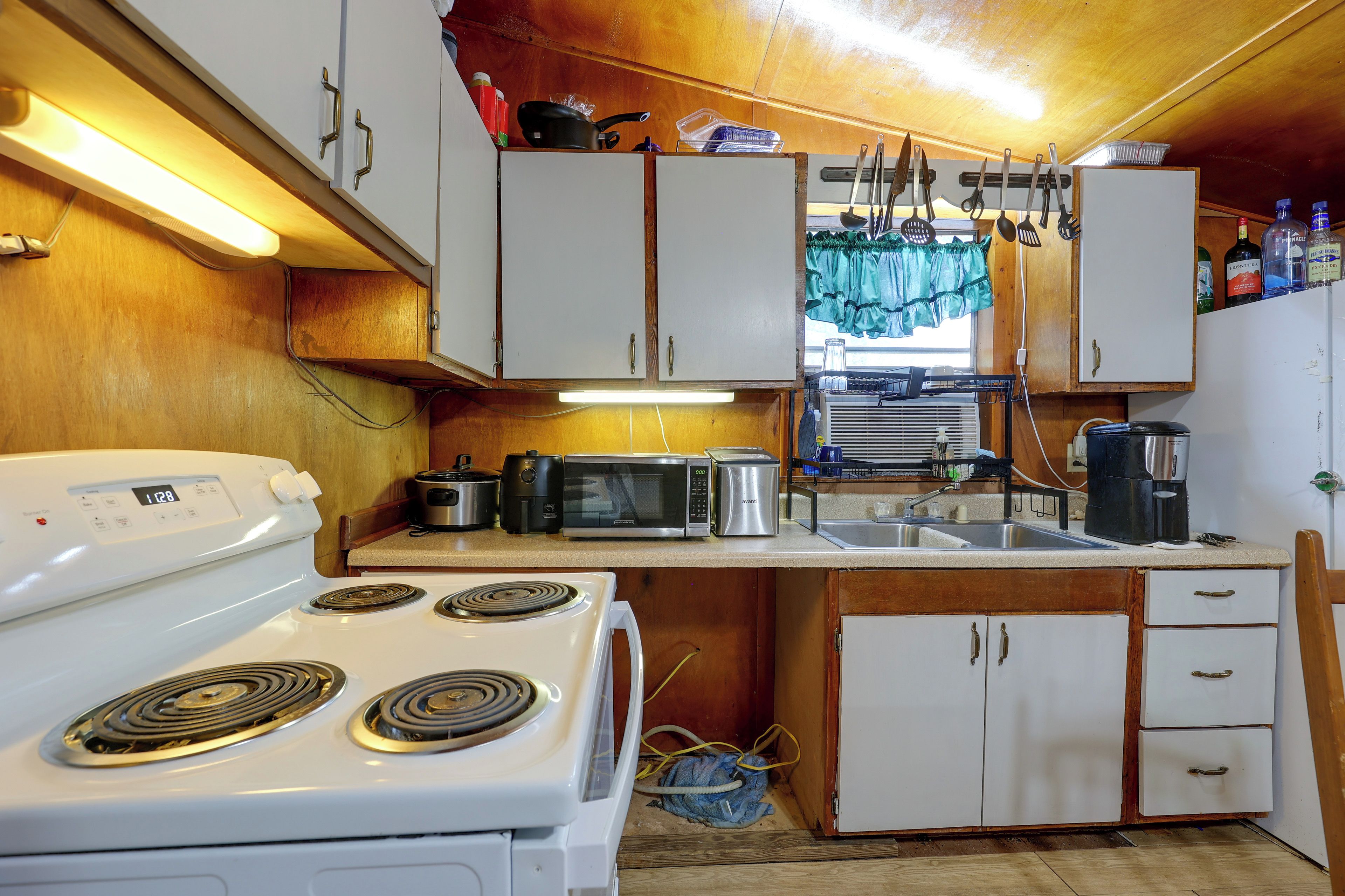 A compact kitchen with a stove, microwave, and various appliances.