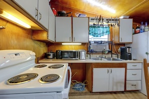 A compact kitchen with a stove, microwave, and various appliances.