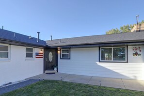 A residential house with a dark front door, a small porch, and a garage door. - Half-acre Yard, Modern Interior! Aurora Home (Aurora)