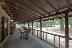 A covered outdoor area with a concrete floor, wooden benches, and a table. - Across From Marina! Over 4k Sq Ft Lodge! (Bainbridge)