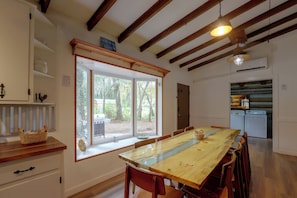 A dining area with a large wooden table, chairs, and a window with a view of the outdoors. - Across From Marina! Over 4k Sq Ft Lodge! (Bainbridge)