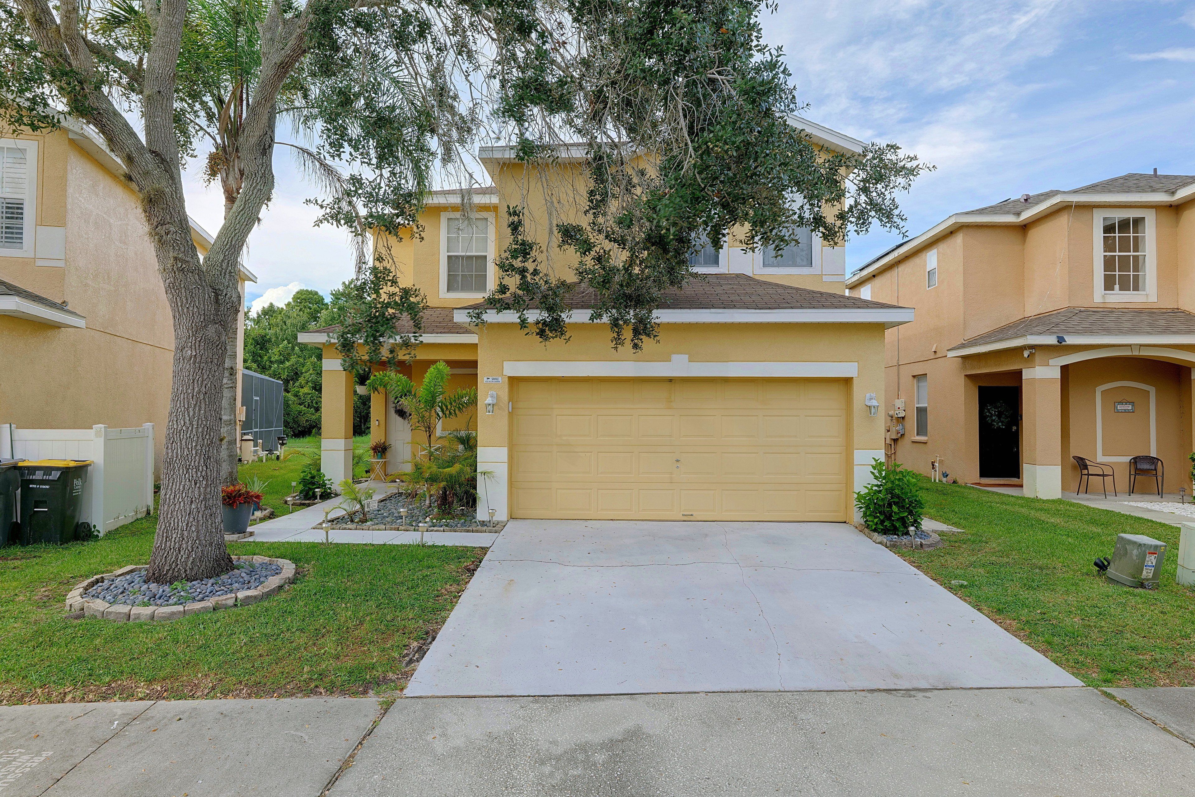 A residential house with a garage, a driveway, and a lawn.