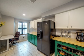A kitchen with a refrigerator, cabinets, a window, and a chair. - 5 Mi to Toyota Music Factory! Unit w/ Pool Access (Irving)