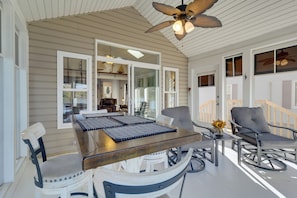 A covered porch with a dining table, chairs, and a ceiling fan. - Fun in the Sun/firepit Fires/sunsets/relaxing (Pleasant Lake)