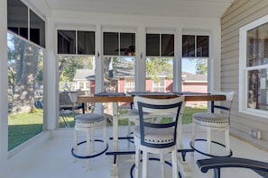 A covered porch with a wooden table and four chairs. - Fun in the Sun/firepit Fires/sunsets/relaxing (Pleasant Lake)