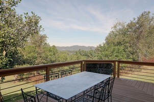 Una terraza con mesa y sillas, con vistas a un paisaje montañoso.