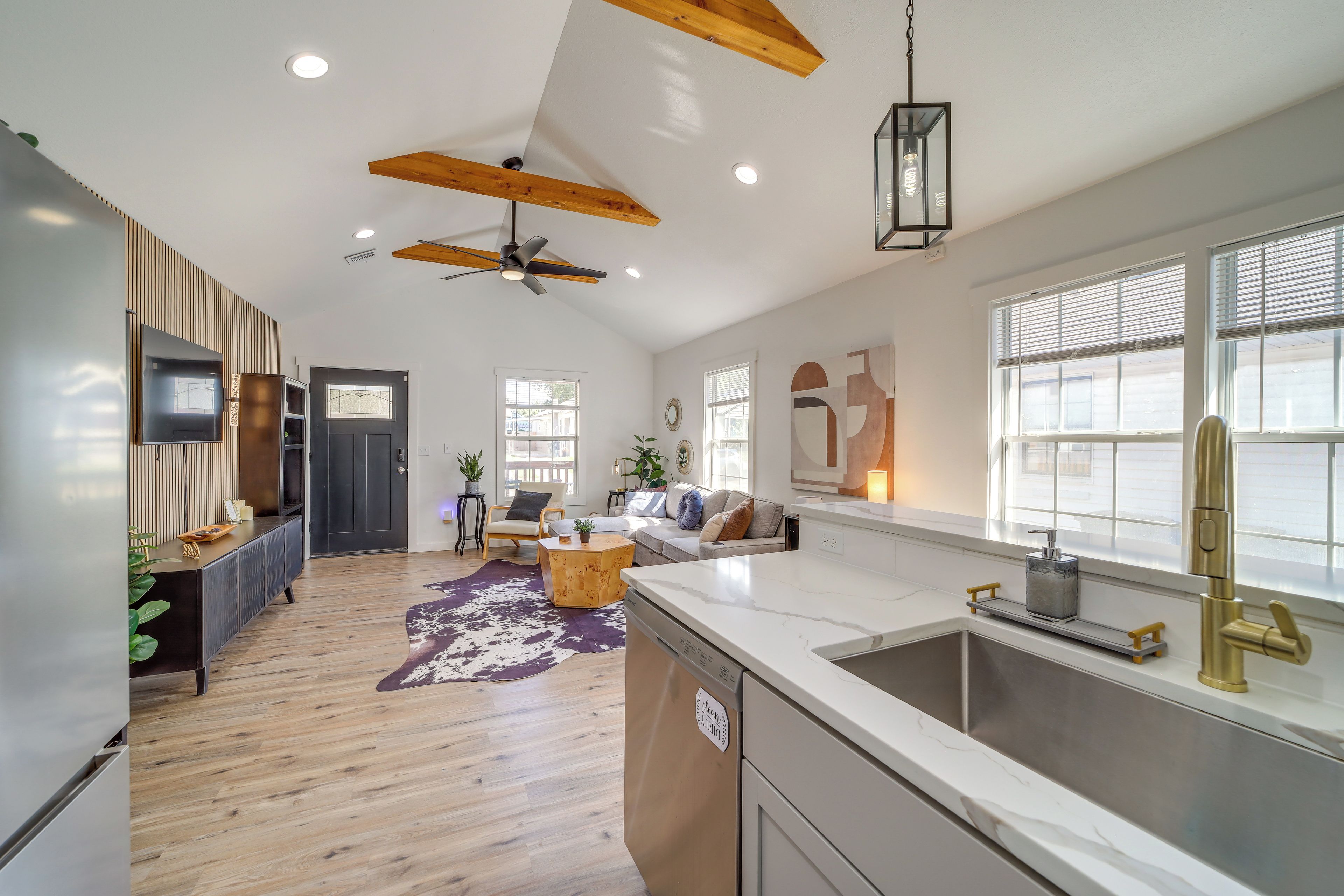 A modern kitchen with a large island, a built-in dishwasher, and a stainless steel sink.