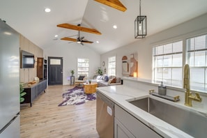 A modern kitchen with a large island, a built-in dishwasher, and a stainless steel sink. - Walk to Cherry Street Shops & Eats! Tulsa Escape (Tulsa)