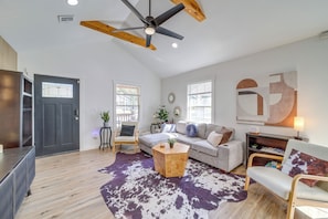 A spacious living room with a ceiling fan, a grey sofa, a wooden coffee table, and a cowhide rug. - Walk to Cherry Street Shops & Eats! Tulsa Escape (Tulsa)