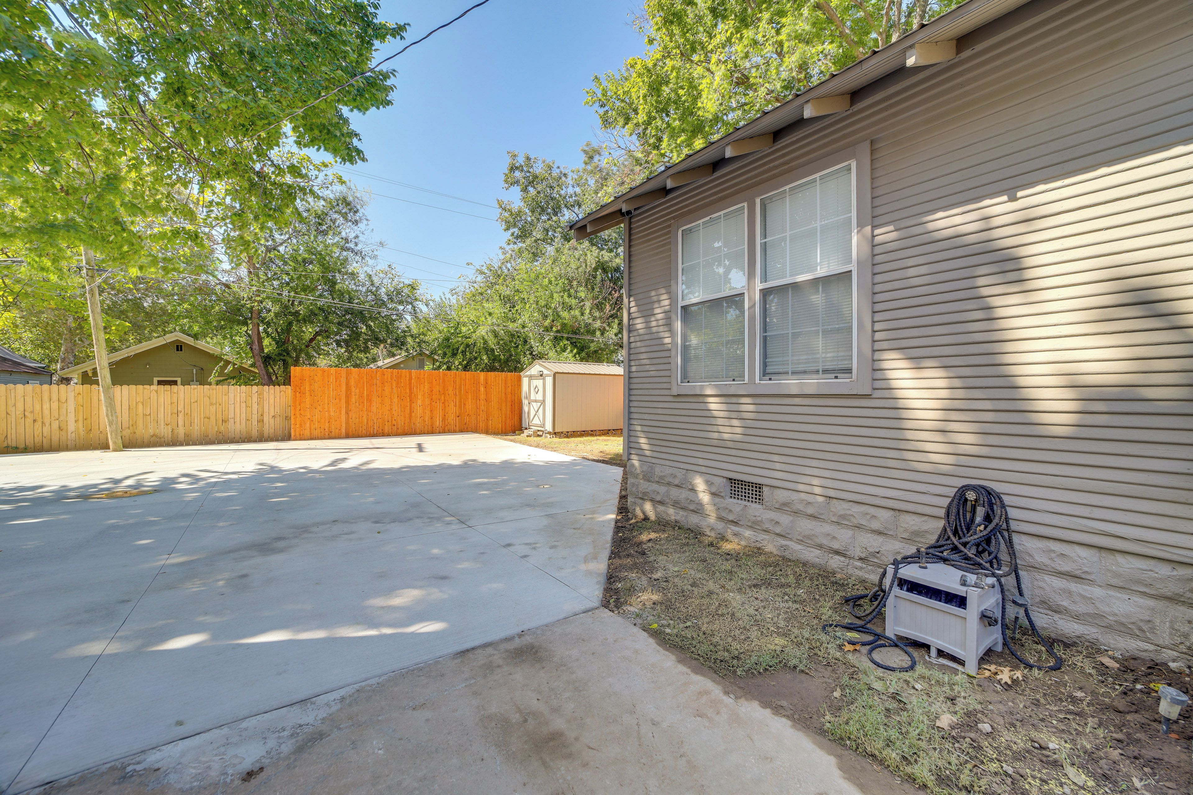 A residential house with a garage, a concrete driveway, and a wooden fence.
