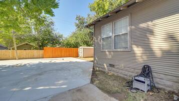 A residential house with a garage, a concrete driveway, and a wooden fence.