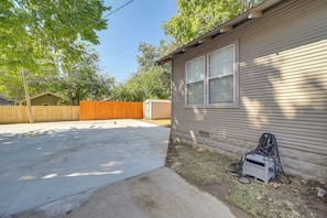 A residential house with a garage, a concrete driveway, and a wooden fence.