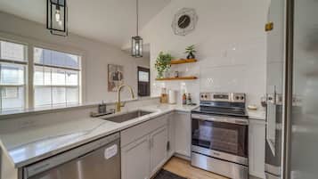 Een moderne keuken met roestvrijstalen apparatuur, een vaatwasser en een inbouwoven.