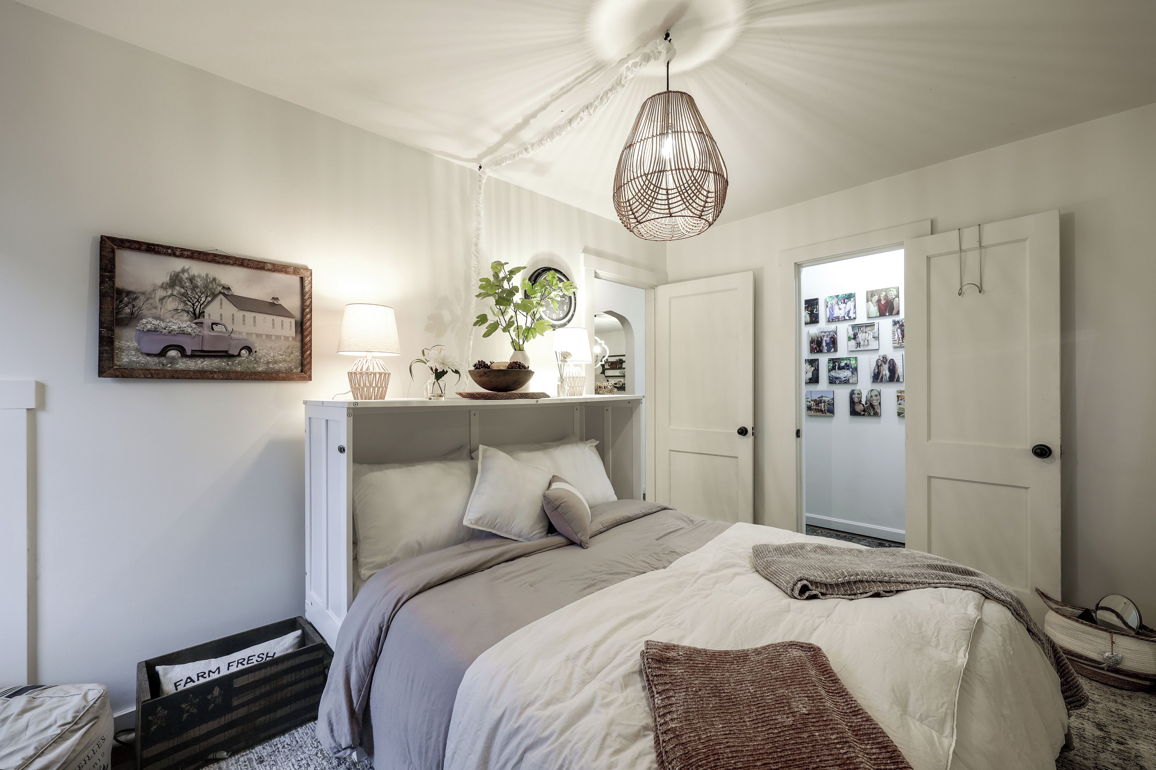 Une chambre à coucher avec un lit, une table de chevet, une lampe et une horloge fixée au mur.