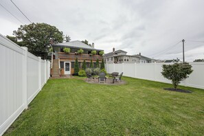 A residential property with a fenced yard, a small patio with outdoor furniture, and a variety of plants. - Comfy & Cozy Home Close to Penn State! (Bellefonte)