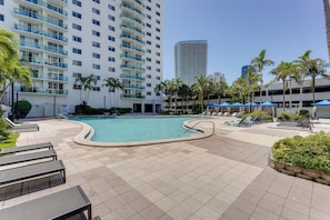 A swimming pool area with lounge chairs and palm trees. - Resort Condo w/ Views in Sunny Isles Beach! (Sunny Isles Beach)