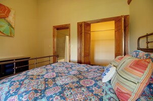Un dormitorio con cama, armario de madera y puerta de baño.