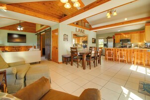 Un'ampia zona giorno con tavolo da pranzo, mobili in legno e una cucina con pensili in legno.