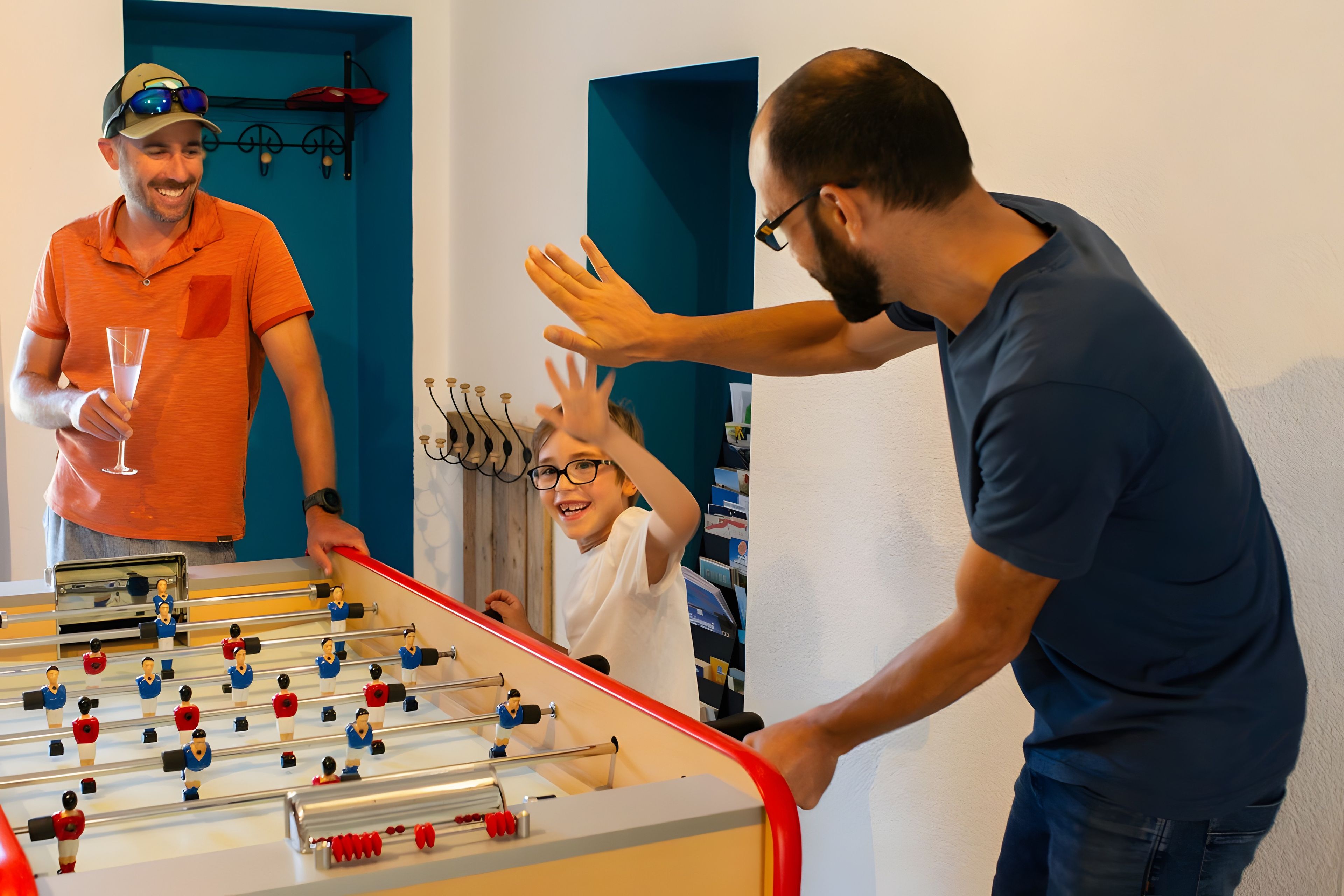 Een tafelvoetbaltafel in een kamer met blauwe wanden en een deur.