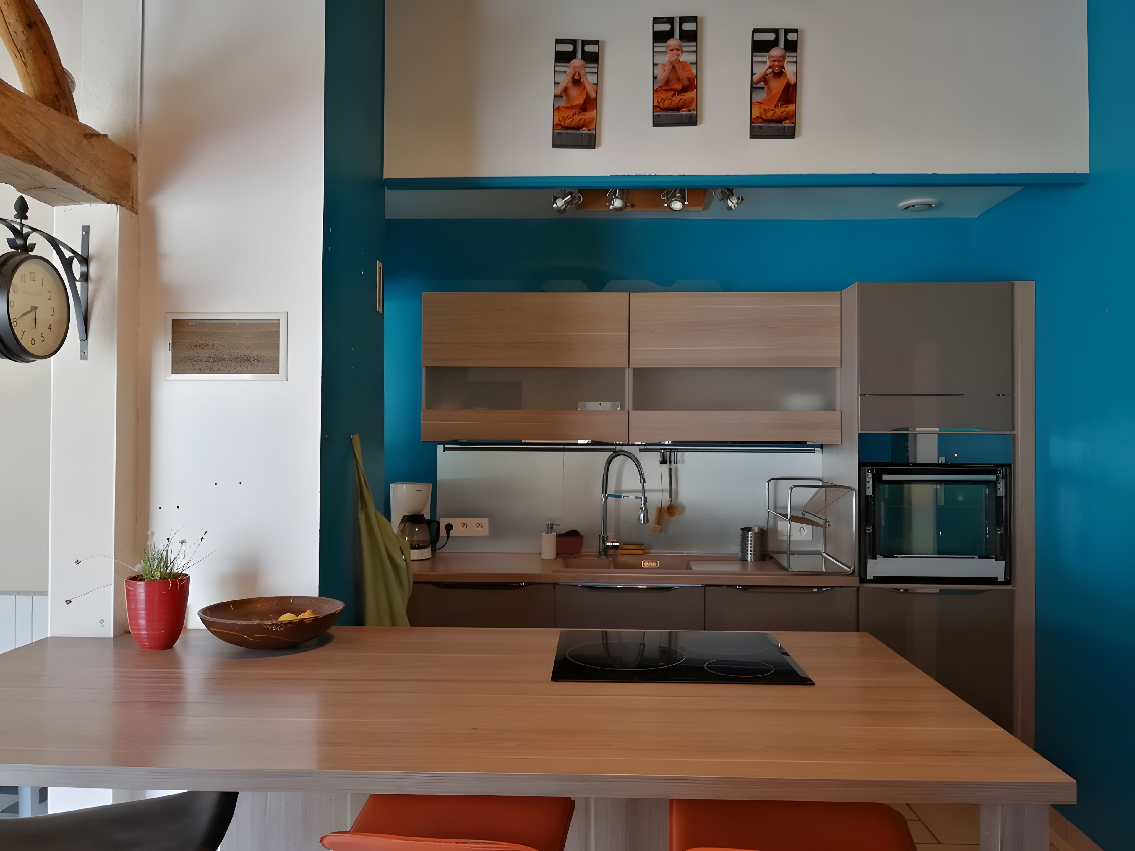 A modern kitchen with a wooden countertop, built-in cabinets, a sink, and a microwave.