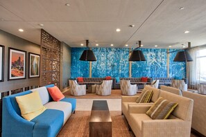 Ein stilvoller Lounge-Bereich mit Sofas, einem Couchtisch und einer blauen Akzentwand.