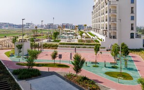 A modern residential complex with a central courtyard featuring a pool, outdoor gym, and landscaped areas. - Serene Yas Island Hideaway w/ Resort Facilities (Abu Dhabi)
