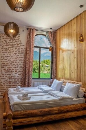 A room with a wooden bed, a window with curtains, and a view of greenery. - Hotel Piano Kvareli (Kvareli)