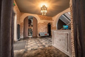 A spacious lobby with a checkered floor, a chandelier, and a television on a cabinet. - Hotel Piano Kvareli (Kvareli)