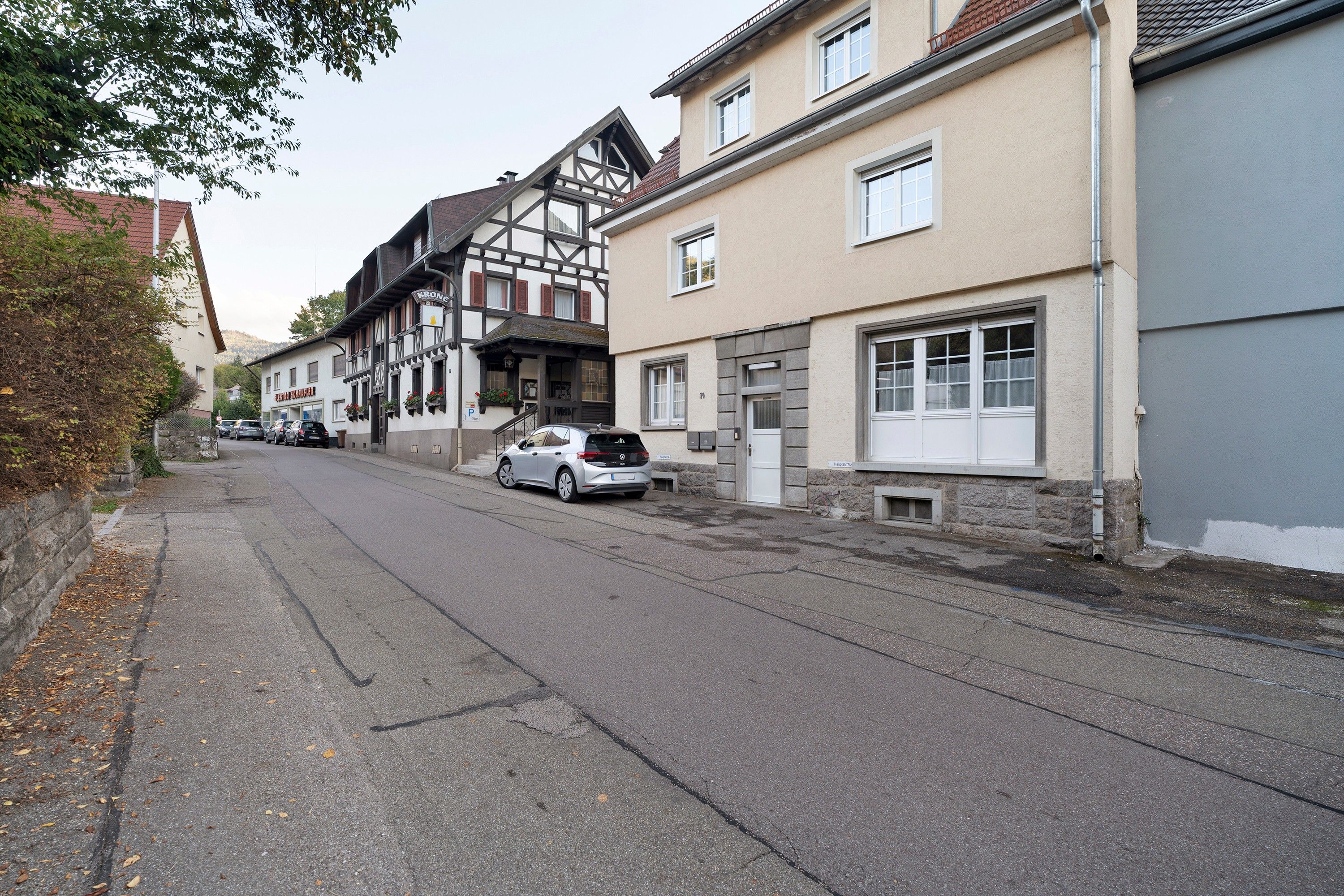 Una calle con arquitectura europea tradicional, que incluye un edificio con entramado de madera y una fachada moderna.