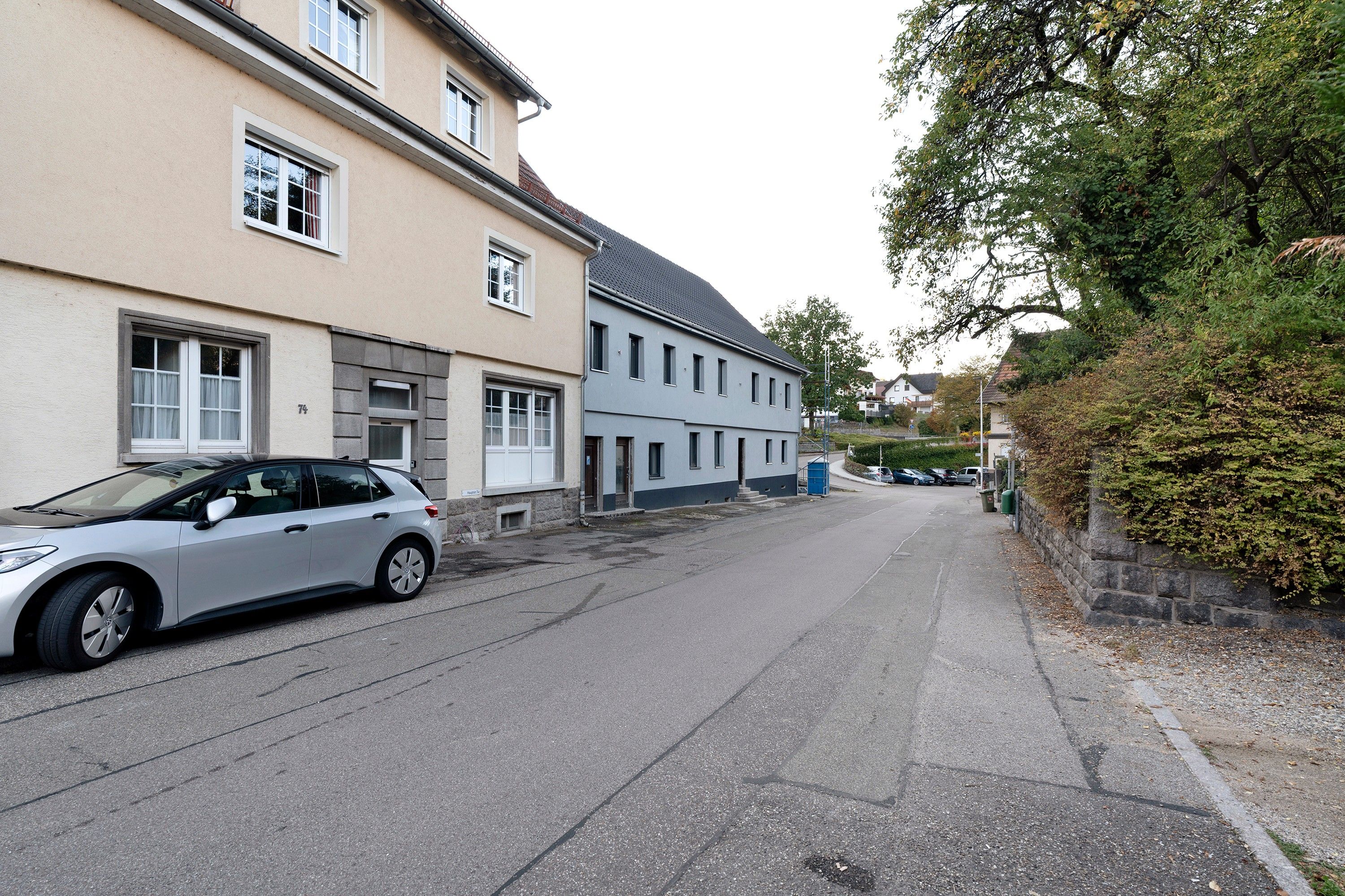 En gade med bygninger, en parkeret bil og en blå himmel.