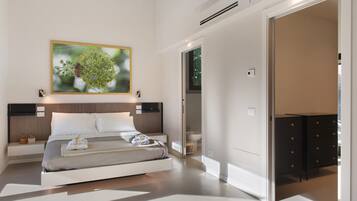 A modern bedroom with a bed, bedside tables, a large framed picture, and a wardrobe.