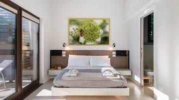 A modern bedroom with a large bed, a wall-mounted painting, and a glass door leading to an outdoor area.