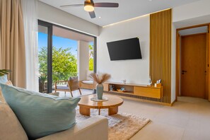 Ein modernes Wohnzimmer mit einer Couch, einem Couchtisch und einem an der Wand befestigten Flachbildfernseher.