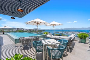 A rooftop pool area with lounge chairs and umbrellas, overlooking a marina with boats. - 1BR condo in La Cruz de Huanacaxtle with pool, gym, WiFi, and AC. (Bahia de Banderas)