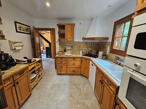 A kitchen with wooden cabinets, a dishwasher, and a stove. - Beautiful cabin for 12–14 people. Winter/Summer in Vaujany, the Greater Alpe d'Huez Area (Vaujany)