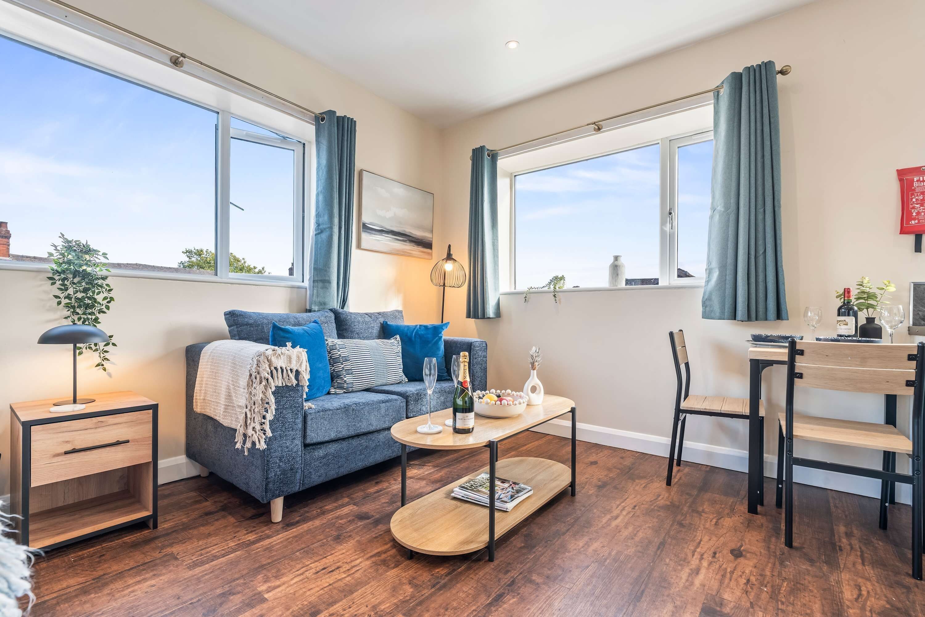 Una sala moderna con sofá, mesa de centro y una zona de comedor con una silla y mesa.