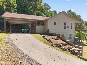 A two-story house with a covered garage and a paved driveway. - Wineberry Ridge Hot Tub Sauna Grill Views (Asheville)
