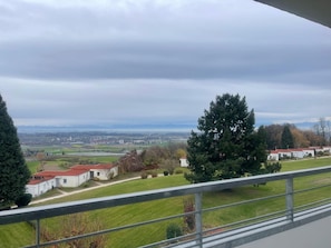 Ein Balkon mit Blick auf ein Wohngebiet, darunter Häuser und eine Kirche.