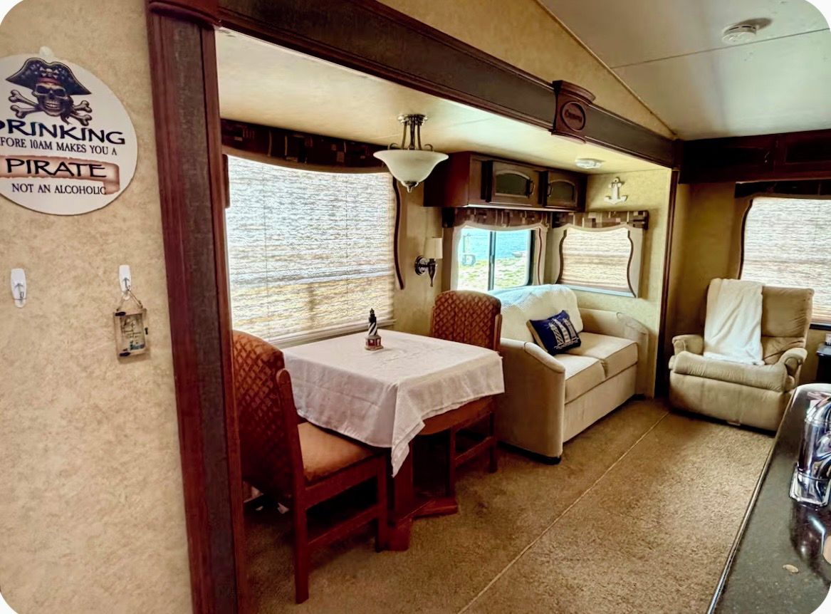 A cozy interior with a dining table, cushioned seating, and a sign on the wall.