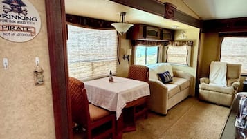A cozy interior with a dining table, cushioned seating, and a sign on the wall.