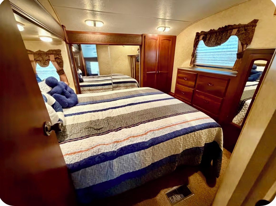Quarto com cama, penteadeira, janela e espelho.
