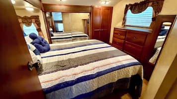 Quarto com cama, penteadeira, janela e espelho.