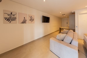 A modern living room with a sofa, artwork on the wall, and a flat-screen TV. - Alvaro by Bhomy (São Paulo)