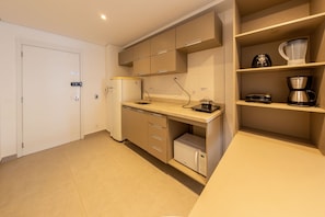 A modern kitchen with a built-in dishwasher, a coffee maker, and a microwave. - Alvaro by Bhomy (São Paulo)