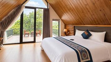 Un dormitorio con una cama grande, techo de madera y vistas al exterior.