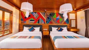 A double room with two beds, wooden headboards, a large window, and a colorful geometric wall art piece.