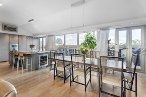 A modern kitchen with a dining area, large windows, and a view of the outdoors. - The Edinburgh Panorama Penthouse (Edinburgh)